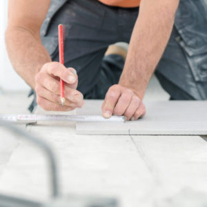 Fliesenleger bei der Arbeit , handwerker schneidet fliesen mit Fliesenleger bei der Arbeit , handwerker schneidet fliesen mit