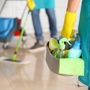 Female janitor with cleaning supplies in kitchen Female janitor with cleaning supplies in kitchen